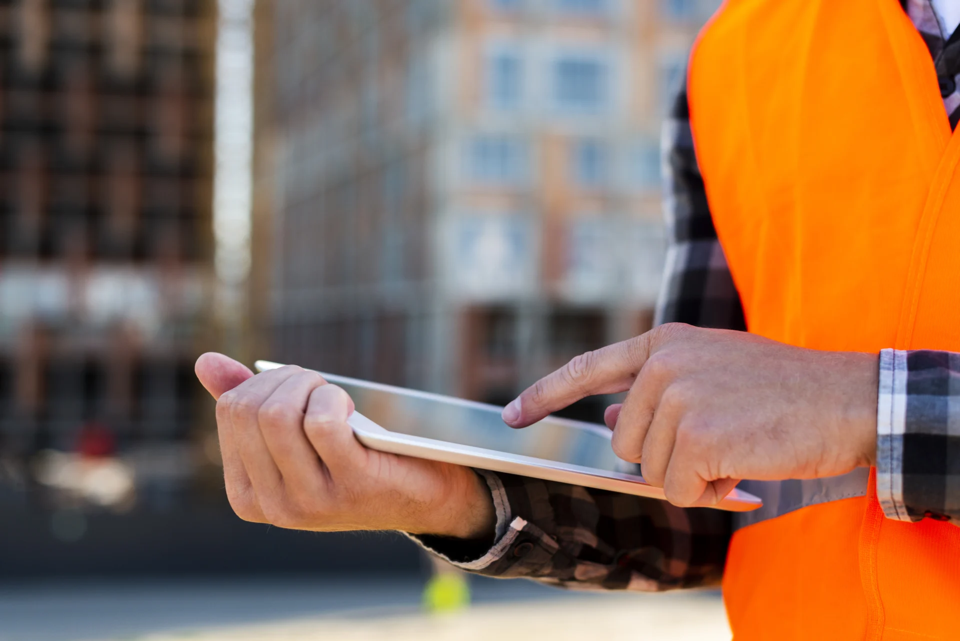 Bauleiter auf der Baustelle nutzt Tablet zur digitalen Projektverwaltung